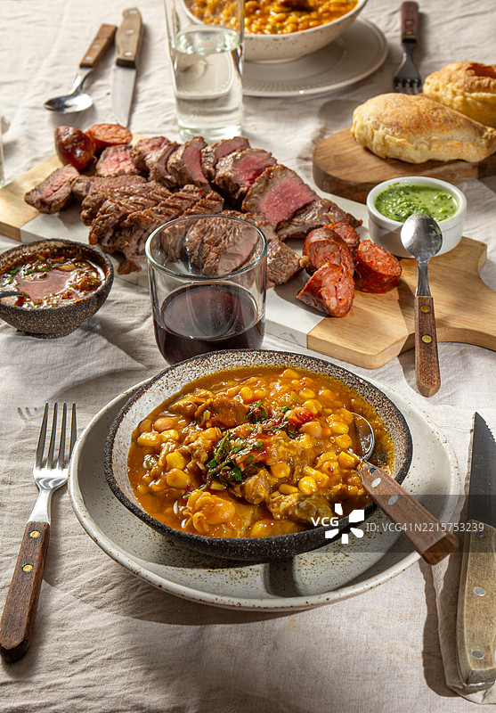 阿根廷独立和革命日的庆祝活动，节日餐桌上摆满了传统美食，如洛克罗、烤肉和馅饼。图片素材