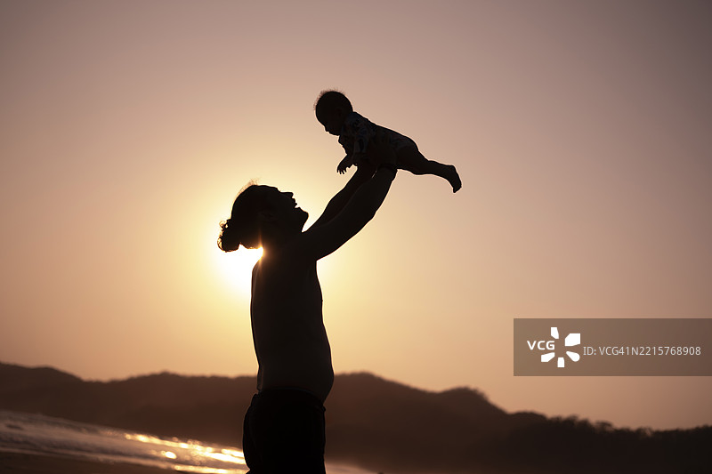 父亲和女儿在海滩上享受快乐时光图片素材