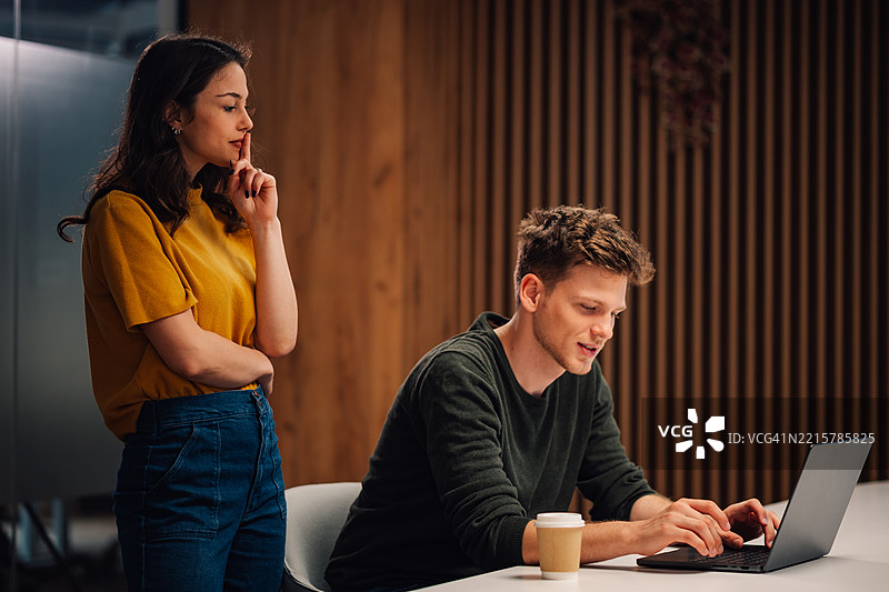 同事们在办公室加班，一名女性做出安静的手势图片素材