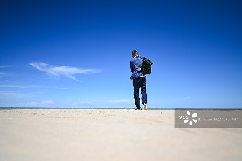 商人在海滩上走向大海图片素材