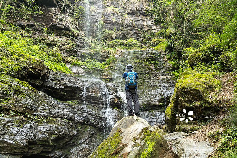 男子在瀑布和溪流中徒步旅行图片素材