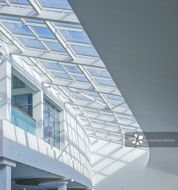 阳光透过现代玻璃屋顶洒入宽敞的中庭图片素材