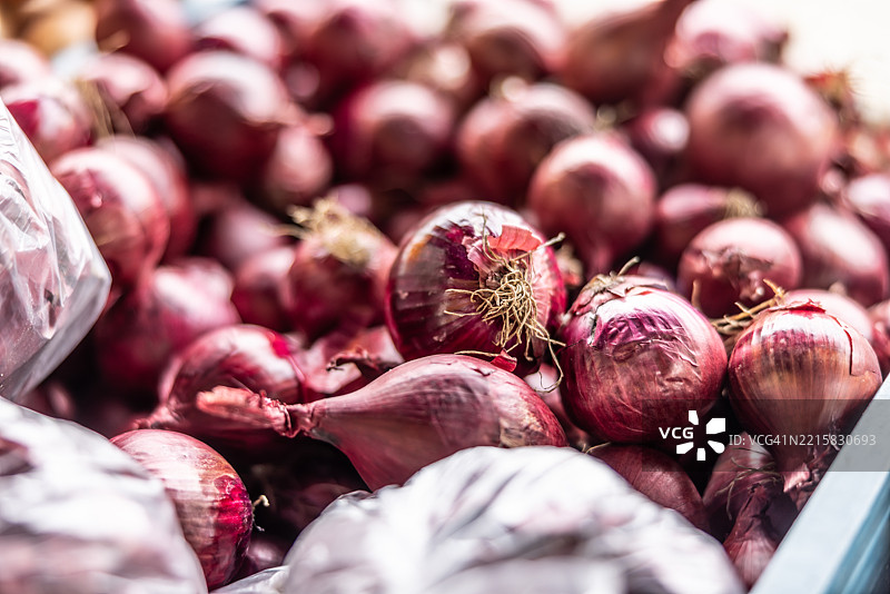 新鲜的西班牙洋葱在农贸市场的托盘箱中待售图片素材