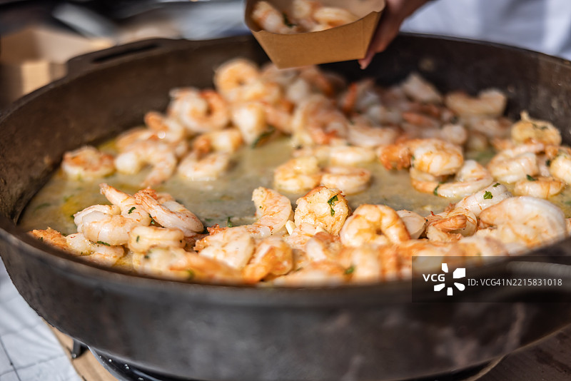 海鲜街头小吃，平底锅里的虾。图片素材