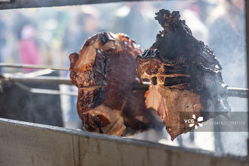 在金属烤架上烧烤至黑色的烤猪肉，旁边是布拉格火腿。图片素材