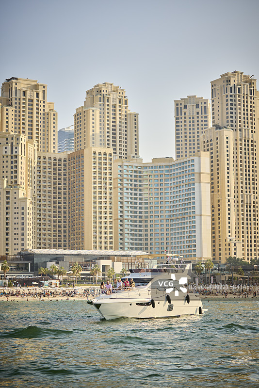 豪华游艇在海上航行，靠近沙滩图片素材