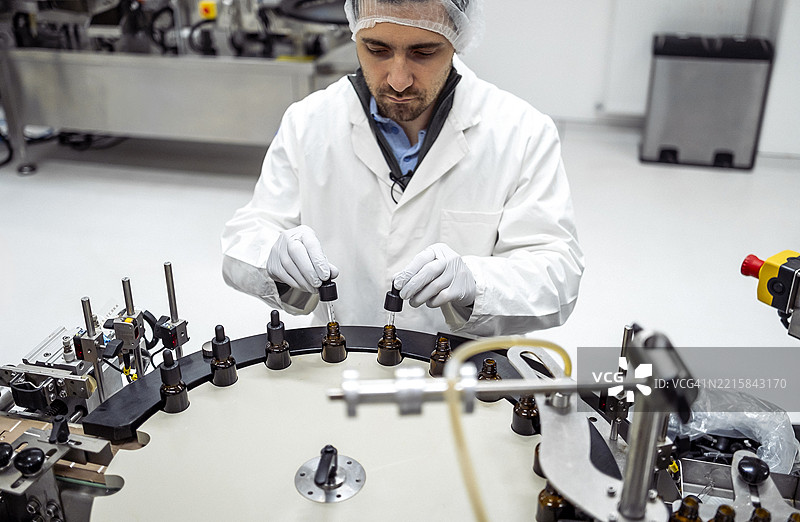 中年男性科学家在现代实验室中进行精确的质量检查图片素材