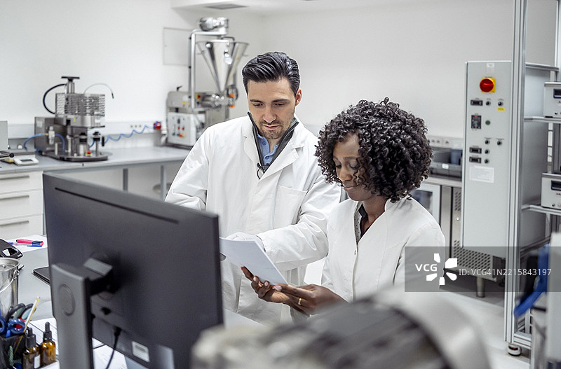 多元化的男性和女性药剂师穿着实验室外套在现代实验室环境中合作图片素材