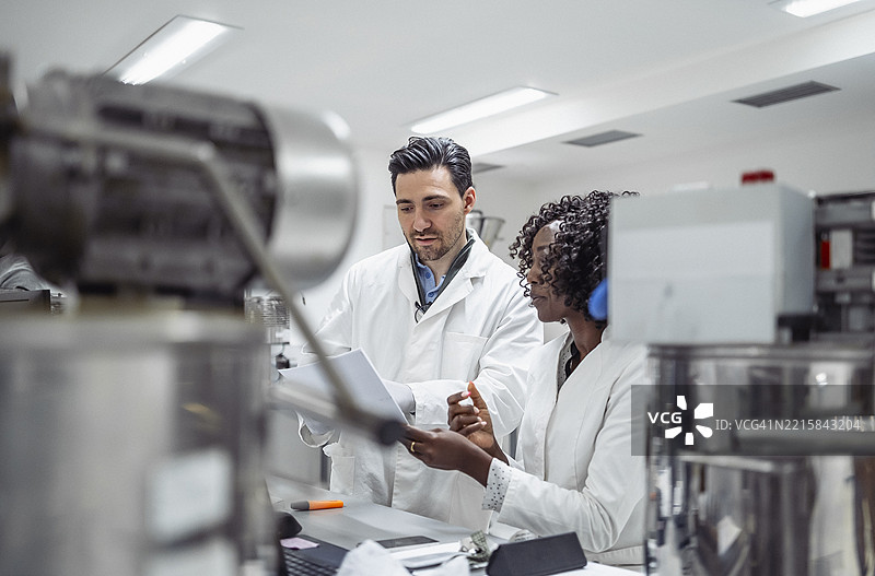 多民族制药科学家在现代实验室环境中审查数据图片素材