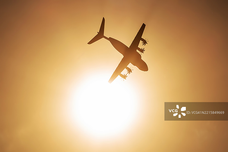 空中客车A-400M军用运输机在日落时飞向明亮的太阳图片素材