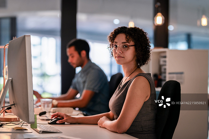 两位专业人士在舒适的现代办公室环境中合作的中景图图片素材