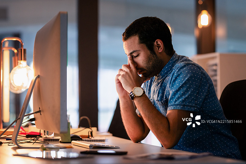 专注的专业人士坐在桌子前，在现代办公室环境中分析电脑上的工作任务图片素材
