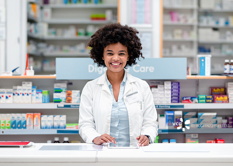 微笑的药剂师在现代药房柜台为顾客服务图片素材