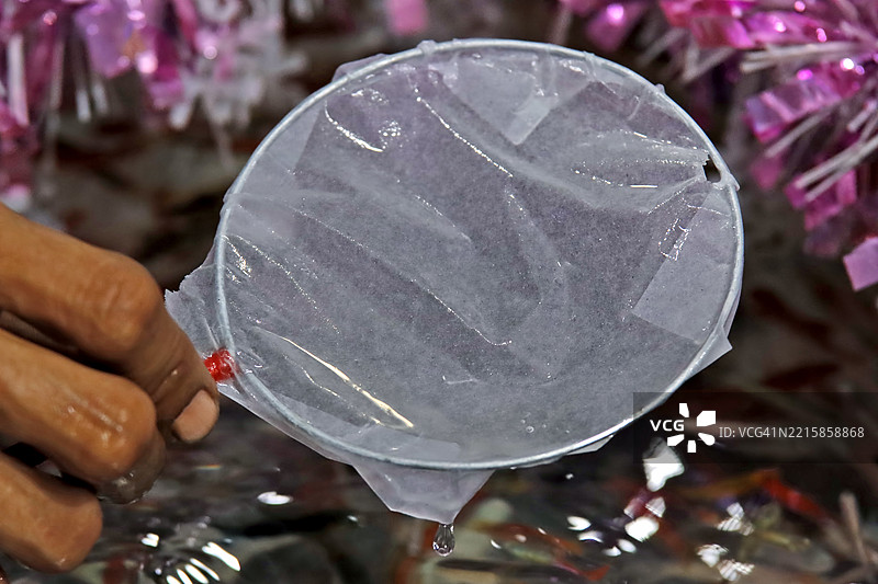 孩子们在市场上玩捞金鱼游戏或用纸勺捞鱼图片素材