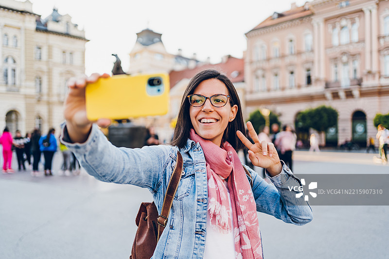 一位年轻女性在城市中使用手机图片素材