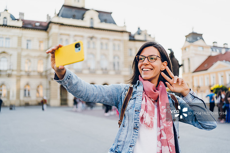 一位年轻女性在城市中使用手机图片素材