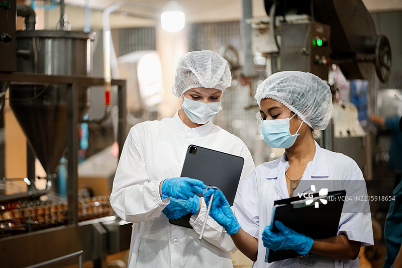 检查员正在罐头食品工厂检查罐头。图片素材