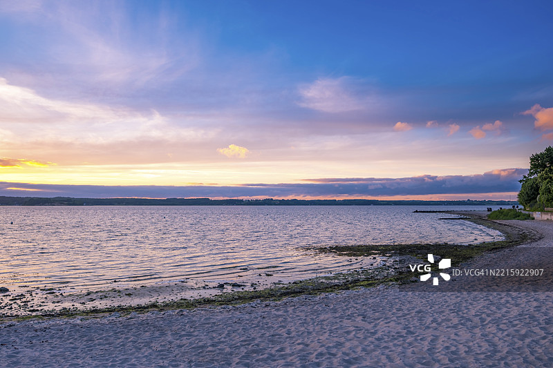 日落时分，德国格吕克斯堡的海滩，温柔的傍晚氛围与宁静的海面。图片素材