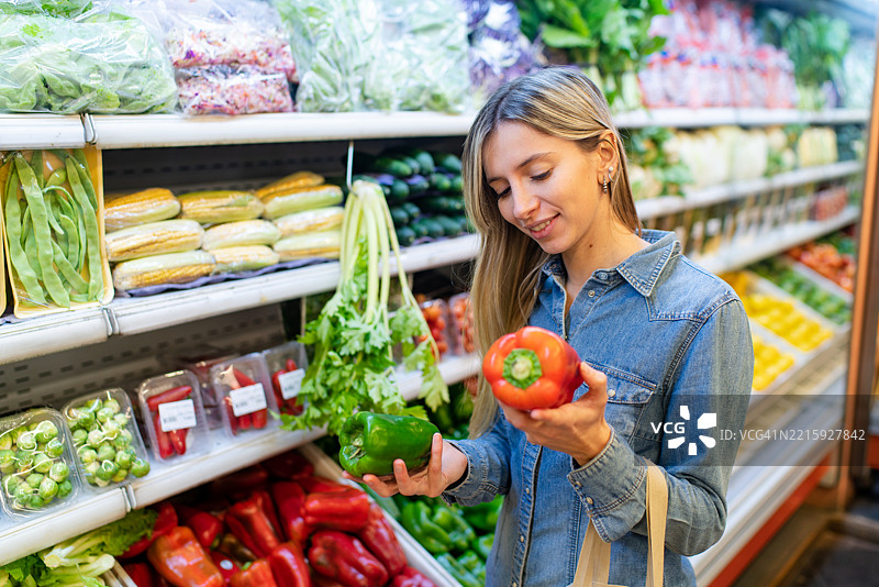 年轻女性在杂货店购买辣椒图片素材