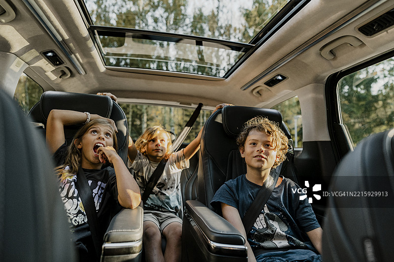 兄弟姐妹在公路旅行中坐在汽车座椅上图片素材