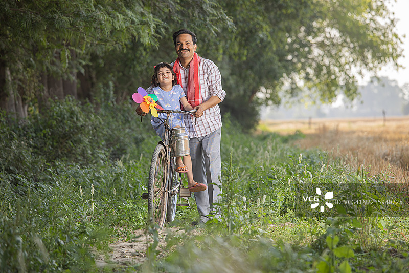 骑自行车给女儿送午餐盒的父亲图片素材