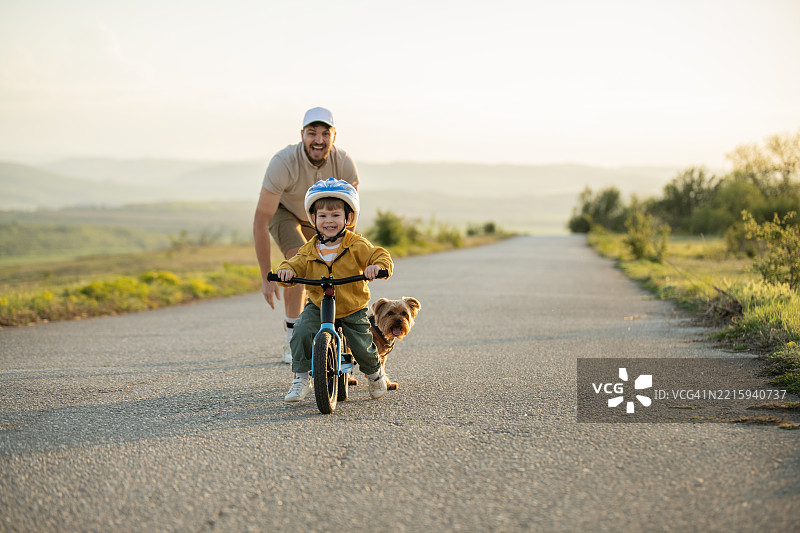 快乐的男孩在路上骑平衡车。图片素材