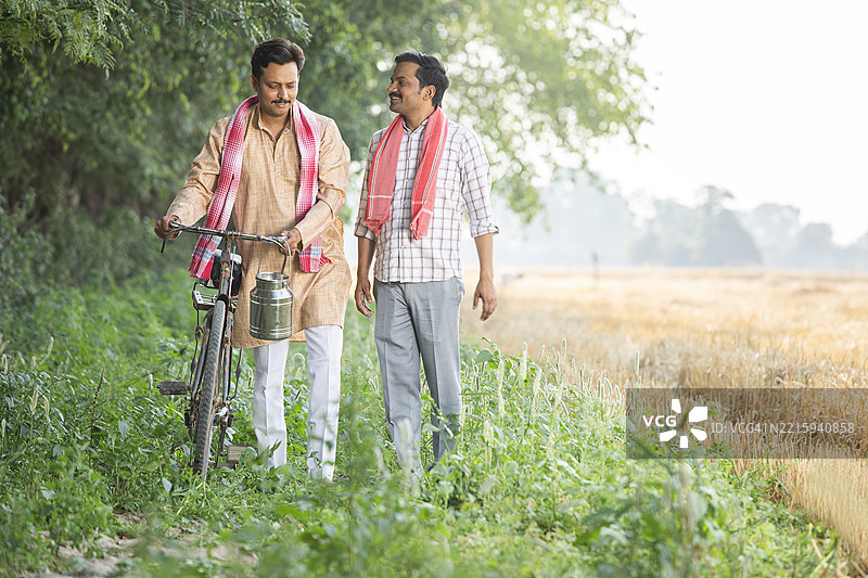 男性朋友在农场散步时交谈图片素材