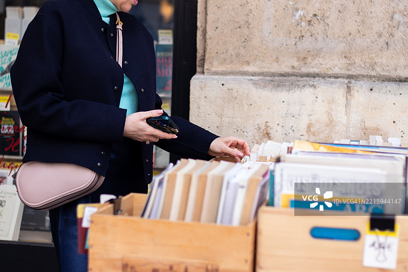 在城市街道的户外书籍销售展示上翻阅书籍的人图片素材