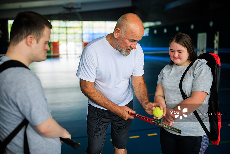 网球教练与唐氏综合症运动员合作图片素材