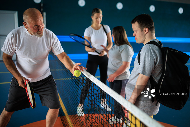 网球教练与唐氏综合症运动员合作图片素材