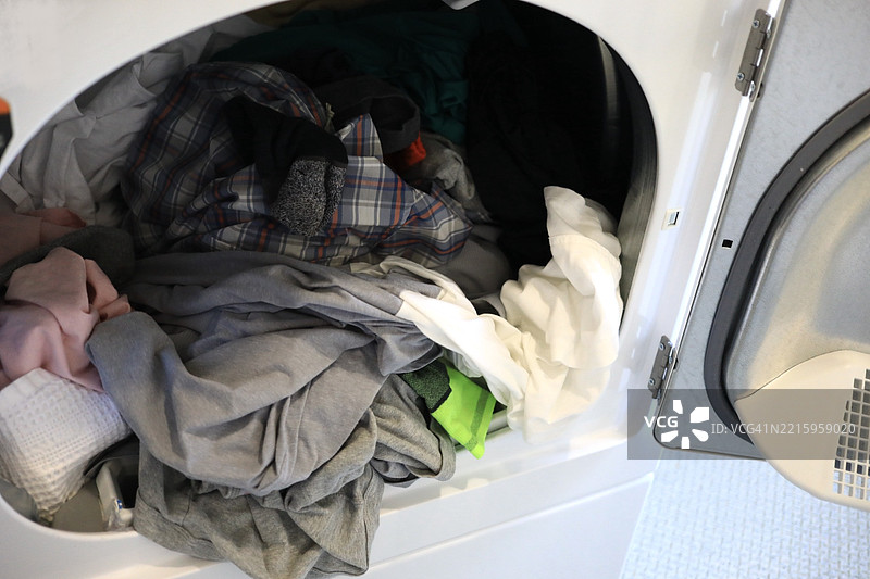 带有一堆干净衣物的烘干机图片素材