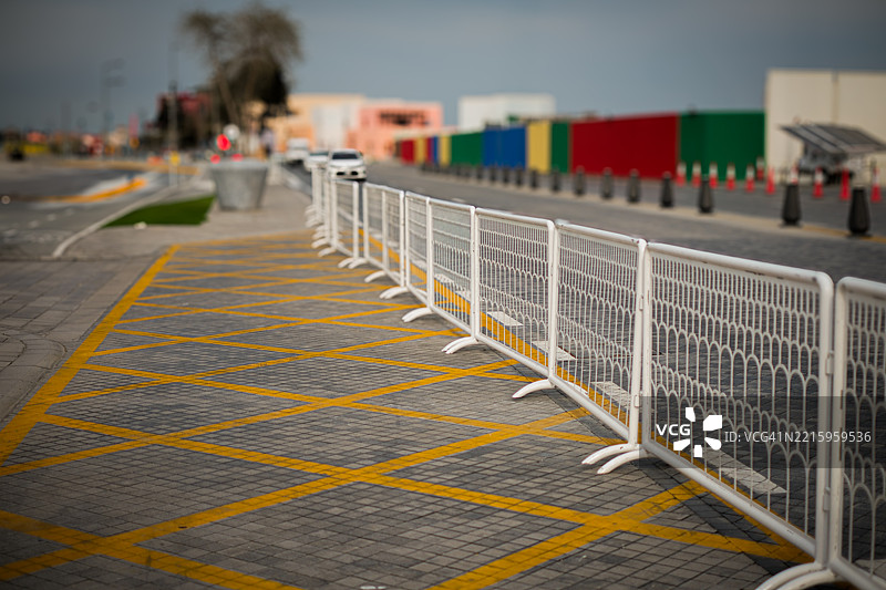 白色围栏旁边的道路黄色线条图片素材