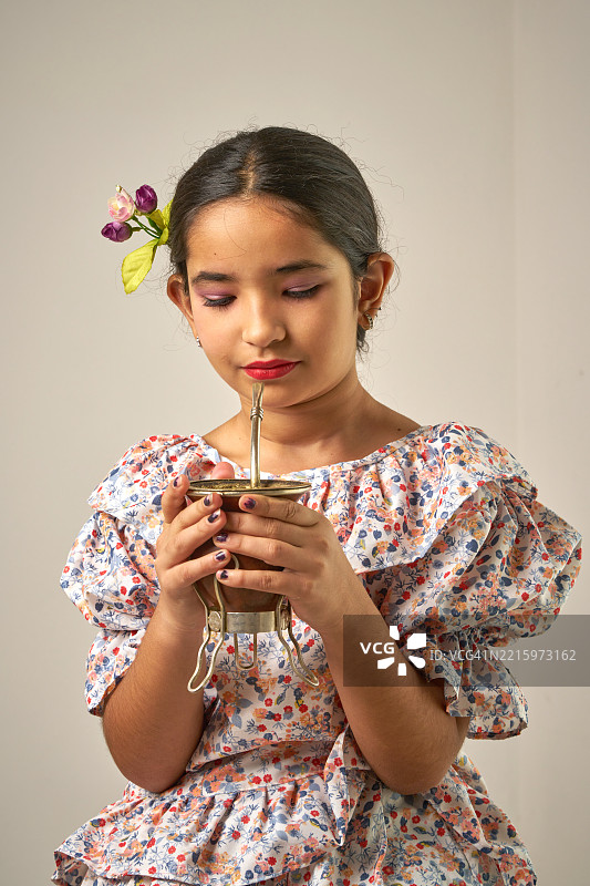 年轻的棕发拉丁女孩在喝马黛茶图片素材