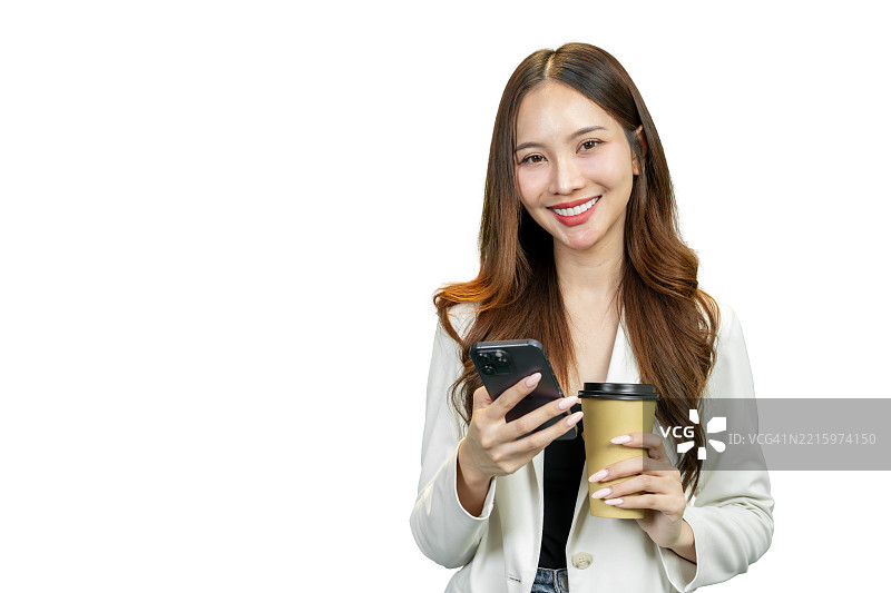 微笑的女性在工作室环境中手持咖啡杯查看手机图片素材