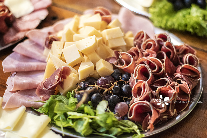 冷切肉、奶酪、葡萄和蔬菜。酸甜食物。拼盘。图片素材