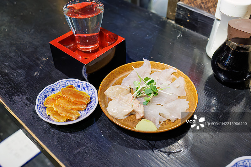 乌鱼子（传统的日本美食，由乌鱼卵腌制而成）。带鱼刺身配肝脏。立山，富山的清酒。图片素材