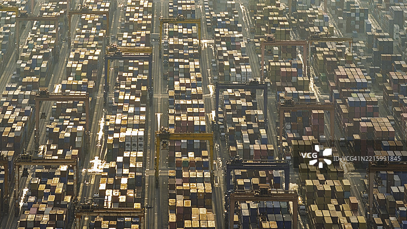 商业港口的鸟瞰图，用于集装箱货物的物流和运输，船厂内有正在工作的起重机桥。图片素材