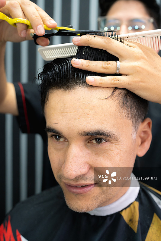 理发师在理发店为男性顾客剪发图片素材
