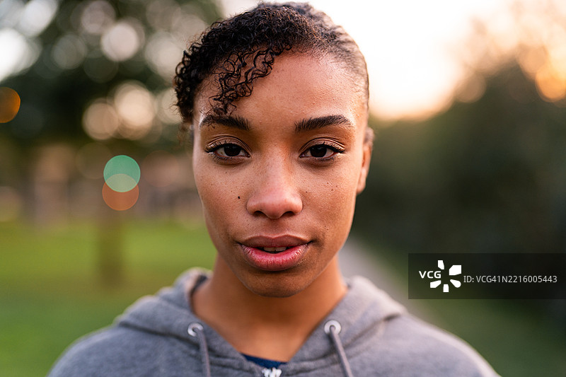 年轻女性在公园里用严肃的表情看着镜头图片素材