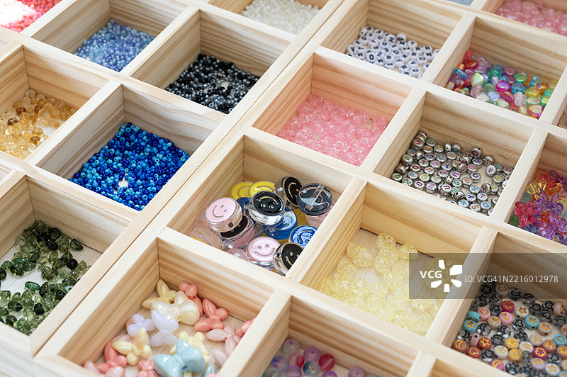 一个装有各种颜色珠子和石头的木盒子图片素材