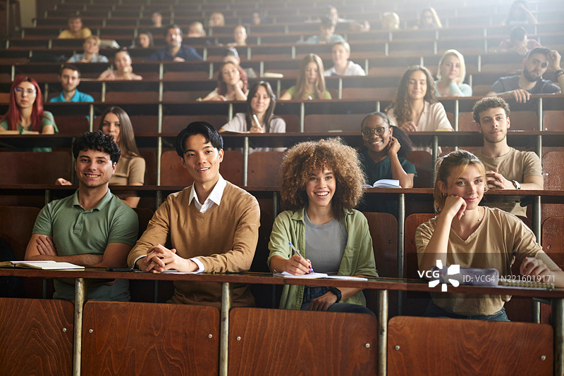 一群快乐的大学生在阶梯教室上课。图片素材