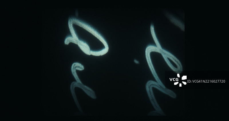 在后台16毫米编辑过程中，抽象的手写符号投影在屏幕上。图片素材