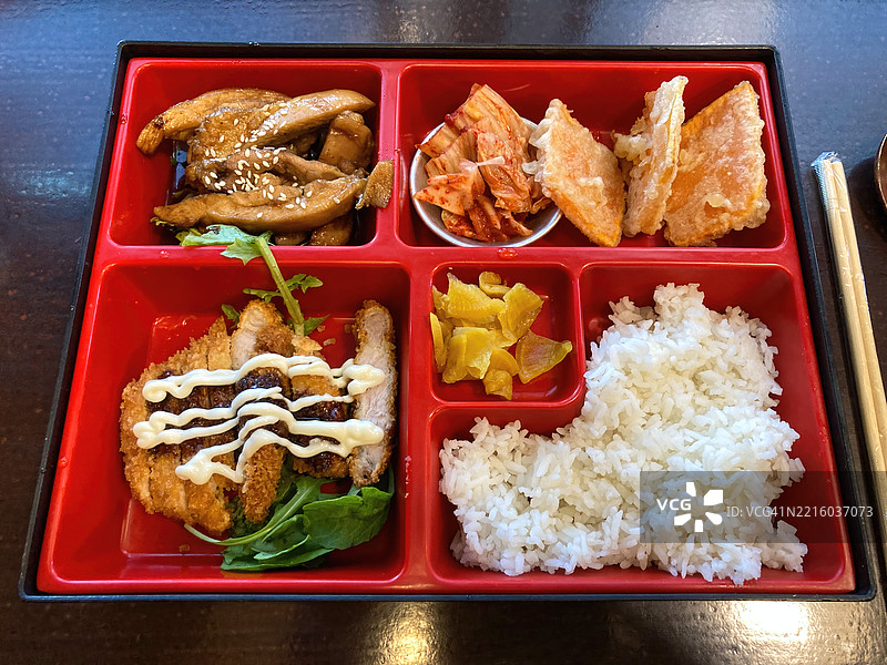 便当盒，内含照烧鸡、泡菜、天妇罗南瓜、猪排、腌制萝卜和米饭图片素材