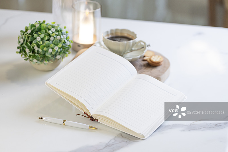 咖啡桌上的空白翻开的书静物。图片素材