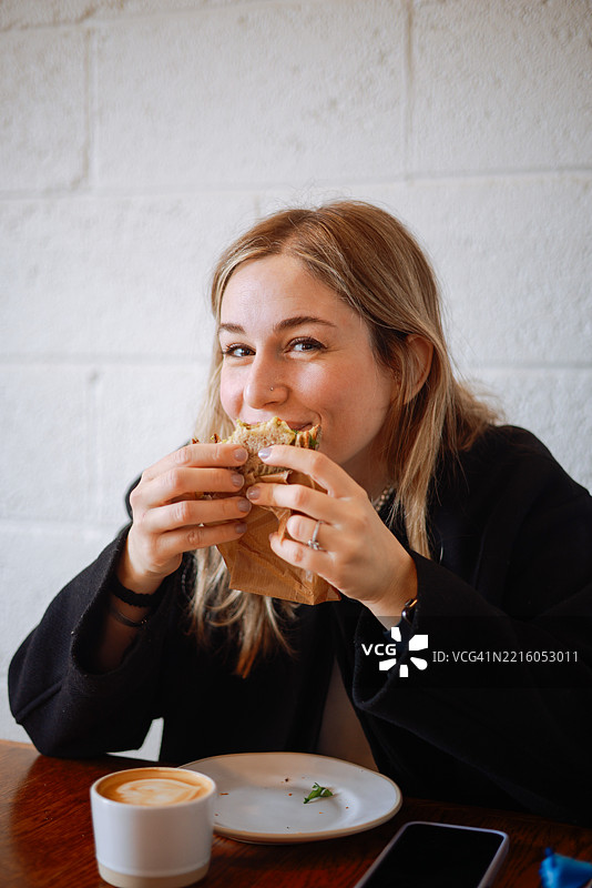 女人手持一片全麦三明治图片素材