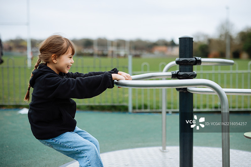 小女孩在旋转木马上玩耍图片素材