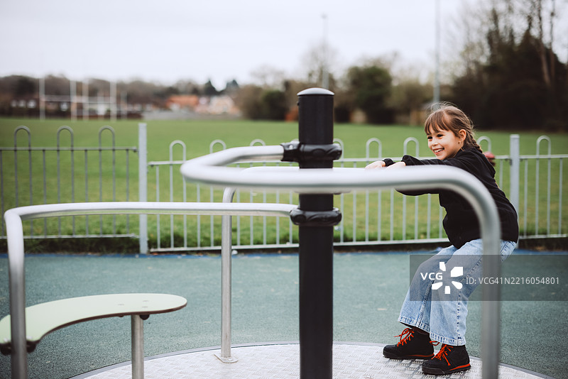 小女孩在旋转木马上玩耍图片素材
