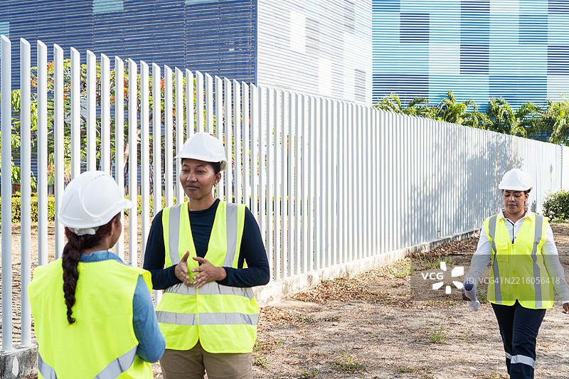 女性工程师在建筑工地附近讨论项目图片素材