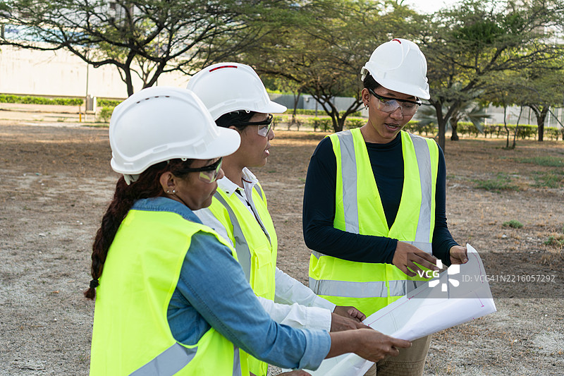 女性建筑工程师在现场审查蓝图图片素材