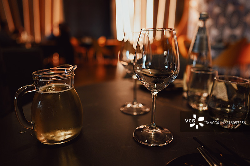 优雅的酒杯和水壶在餐厅桌上闪闪发光图片素材